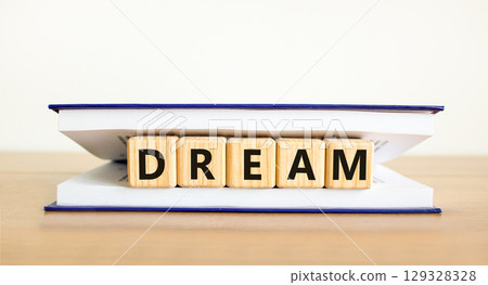 Dream symbol. Concept word Dream on beautiful wooden blocks in book. Beautiful wooden table white background. Business lifestyle dream concept. Copy space. Dream symbol. Concept word Dream on beautiful wooden blocks in book. Beautiful wooden table white background. Business lifestyle dream concept. Copy space. 129328328