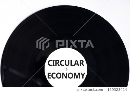 Circular economy symbol. Concept words Circular economy on beautiful black vynil disk. Beautiful white table white background. Business circular economy concept. Copy space. 129328424