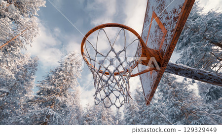A weathered basketball hoop in a snow-covered forest clearing 129329449