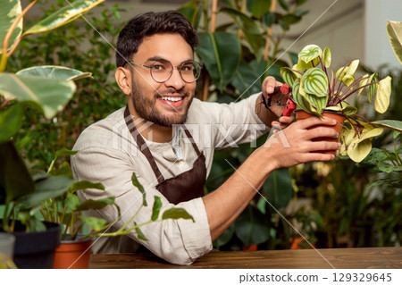 Flower shop assistant cutting the plants and looking busy 129329645