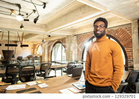Portrait of successful black businessman in turtleneck posing in workspace Portrait of successful black businessman in turtleneck posing in workspace 129329701