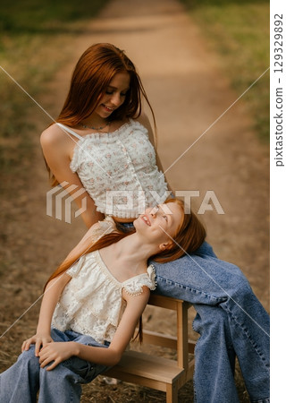 Two Girls Enjoying a Relaxing Moment Outdoors Two Girls Enjoying a Relaxing Moment Outdoors 129329892