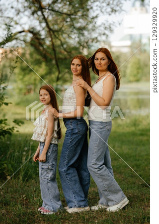 Three Generations of Women Standing Outdoors Smiling 129329920