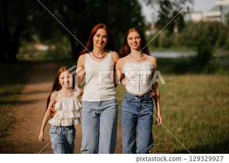 Happy Family Walking Together in Scenic Park Pathway 129329927