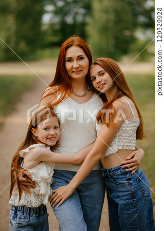 Mother and Daughters Embracing Outdoors in Nature 129329928