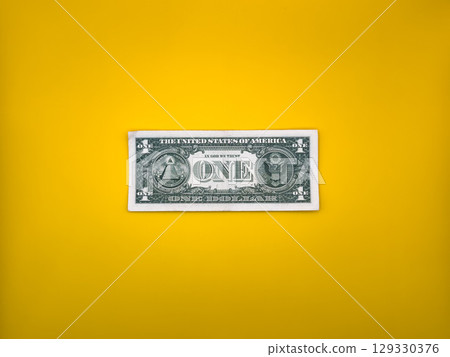 Old green one dollar bill on bright yellow background, top view Old green one dollar bill on bright yellow background, top view 129330376
