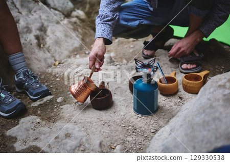 Camping Scene with Copper Pot and Outdoor Cookware in Rustic Mountain Setting Camping Scene with Copper Pot and Outdoor Cookware in Rustic Mountain Setting 129330538
