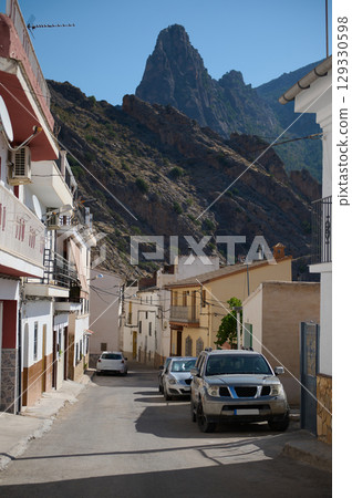Picturesque Village Street with Rocky Mountain in the Background on a Sunny Day Picturesque Village Street with Rocky Mountain in the Background on a Sunny Day 129330598