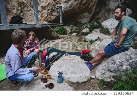 Group of Friends Enjoying a Break Amidst Rocks and Nature in a Scenic Outdoor Setting 129330624