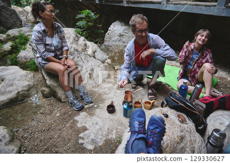 Friends Enjoying an Outdoor Coffee Break While Camping in Nature 129330627