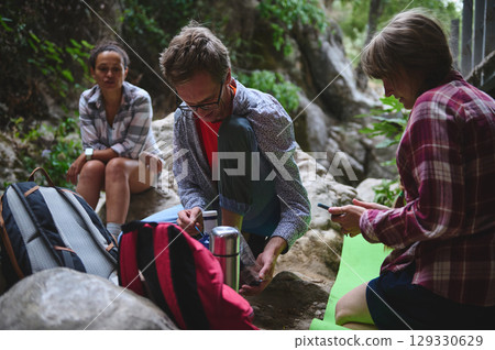 Friends Relaxing Outdoors as They Take a Break During a Nature Hike Friends Relaxing Outdoors as They Take a Break During a Nature Hike 129330629
