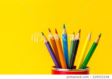 Brightly colored pencils standing in a red cup on a vibrant yellow background. Concept of creativity, art, education, back to school, and design. Minimalist and playful composition with copy space. Brightly colored pencils standing in a red cup on a vibrant yellow background. Concept of creativity, art, education, back to school, and design. Minimalist and playful composition with copy space. 129331248