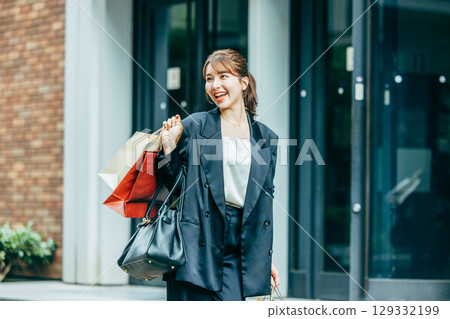 提著購物袋的年輕女子 129332199