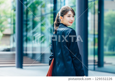 Young business woman walking in the office district 129332226