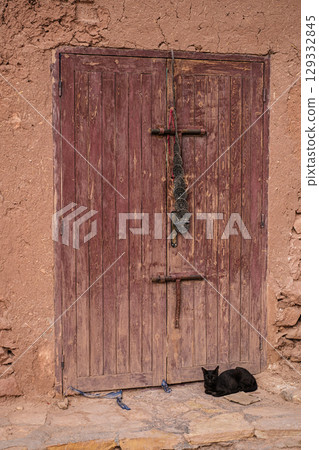 Black cat in front of the Ait Benhaddou door in Morocco 129332845
