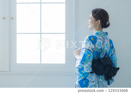 A woman in a yukata by the window A woman in a yukata by the window 129333806