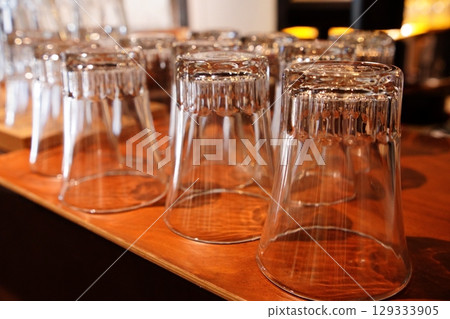 木桌上倒置排列的玻璃杯 129333905