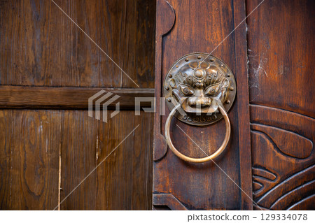 Detailed close-up of an ornate bronze door knocker found in a tr Detailed close-up of an ornate bronze door knocker found in a tr 129334078