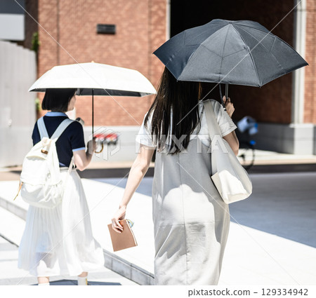 兩名女學生撐著陽傘行走的背影 129334942