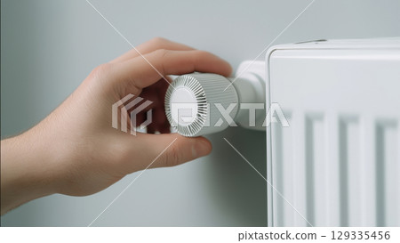 Hand adjusts radiator thermostat, created with AI 129335456