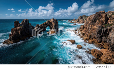 Remote windswept coastline, dramatic rock arch, rugged cliff, turquoise sea, blue sky Remote windswept coastline, dramatic rock arch, rugged cliff, turquoise sea, blue sky 129336148