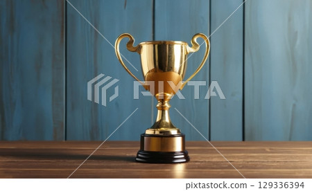 Golden Trophy on Wooden Table with Blue Wooden Background 129336394
