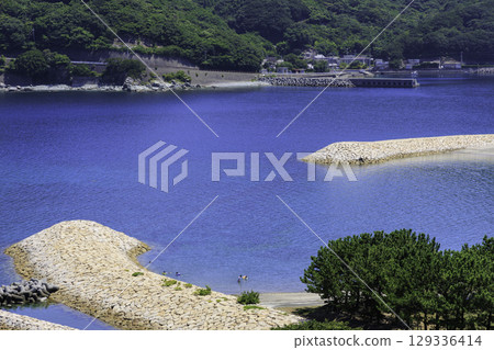 The summer scenery of Moon Beach Inoura, with its beautiful half-moon shaped sandy beach and blue sea 129336414