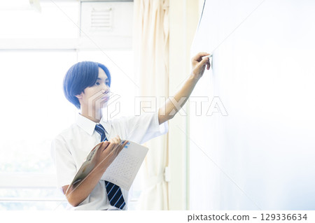 一名男高中生在黑板上寫答案 一名男高中生在黑板上寫答案 129336634