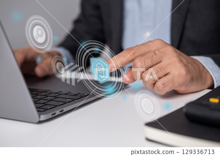 Close-up of businessman's hand touching virtual security application. Close-up of businessman's hand touching virtual security application. 129336713
