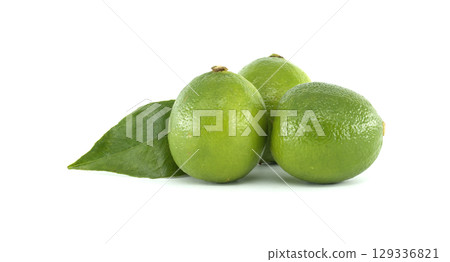 Fresh limes showing their vibrant green color and leaf on white background Fresh limes showing their vibrant green color and leaf on white background 129336821
