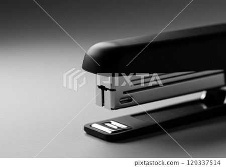 Black Office Stapler on Gray Background Black Office Stapler on Gray Background 129337514