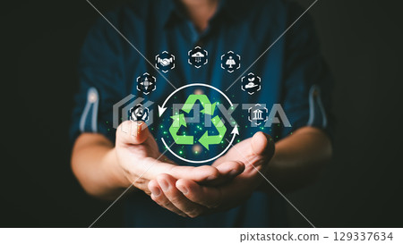 person holds a glowing recycling symbol surrounded by eco-friendly icons, representing sustainability, energy efficiency, and corporate responsibility. green business practices and environmental care. person holds a glowing recycling symbol surrounded by eco-friendly icons, representing sustainability, energy efficiency, and corporate responsibility. green business practices and environmental care. 129337634