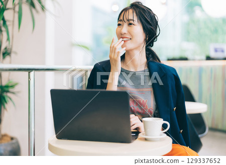 一位時尚的中年女性在咖啡館使用電腦 129337652