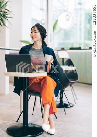 A stylish middle-aged woman using a computer in a cafe 129337653