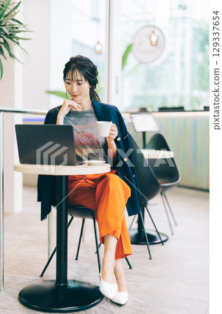一位時尚的中年女性在咖啡館使用電腦 129337654