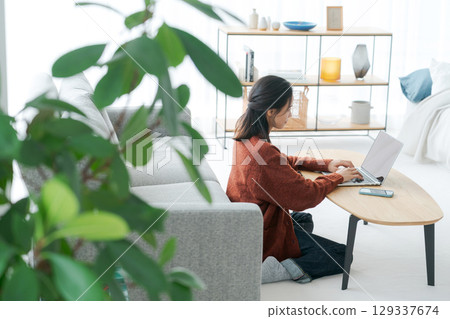 在客廳裡操作個人電腦的女人 129337674