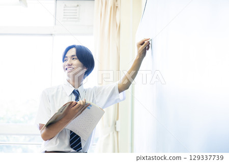 一名國中男生在黑板前演講 一名國中男生在黑板前演講 129337739