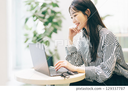 A woman using a computer in a cafe A woman using a computer in a cafe 129337787