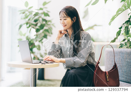 一位女士在咖啡館使用電腦 129337794