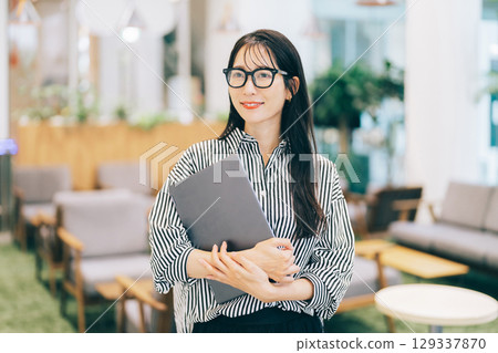 辦公室裡拿著筆記型電腦的女商人 129337870