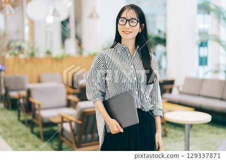 辦公室裡拿著筆記型電腦的女商人 129337871