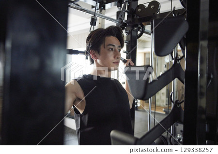 身穿運動服的日本年輕男子在健身房進行肌力訓練 身穿運動服的日本年輕男子在健身房進行肌力訓練 129338257