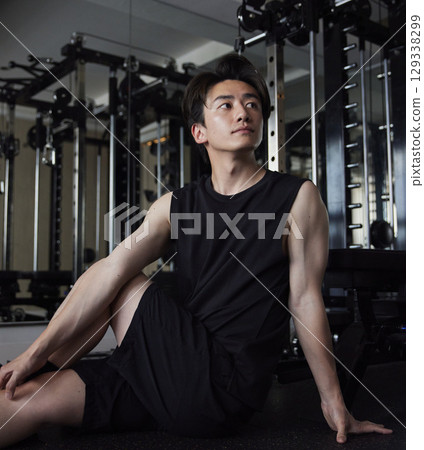 一名身穿運動服的男子在訓練前做伸展運動。 一名身穿運動服的男子在訓練前做伸展運動。 129338299