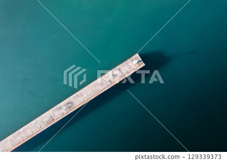 Aerial View of Seaside Jetty in Tranquil Waters Aerial View of Seaside Jetty in Tranquil Waters 129339373