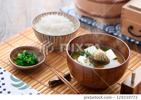 熱氣騰騰的味噌湯，配上碎海帶、豆腐和白米飯。日式早餐，家常菜，健康餐飲的形象。 129339772