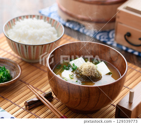 Steaming miso soup with grated kelp and tofu and white rice. Japanese breakfast, home cooking, healthy dining image. Steaming miso soup with grated kelp and tofu and white rice. Japanese breakfast, home cooking, healthy dining image. 129339773