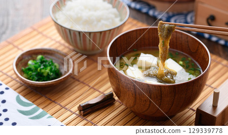 Steaming miso soup with grated kelp and tofu and white rice. Japanese breakfast, home cooking, healthy dining image. 129339778