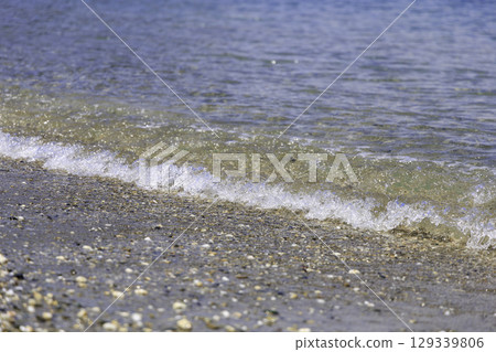 Close-up of small waves and a pebble beach 129339806