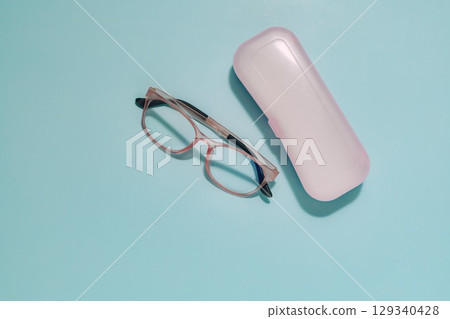Pink Glasses and Case on Blue, Vision and Eye Care Essentials Pink Glasses and Case on Blue, Vision and Eye Care Essentials 129340428