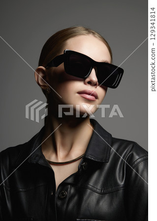 Beautiful young woman in sunglasses. blond girl in black glasses and leather coat Beautiful young woman in sunglasses. blond girl in black glasses and leather coat 129341814